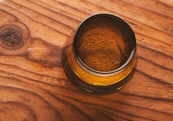 Vaso de agua con aceite de oliva sobre una tabla de madera