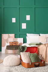 Interior of bedroom with poufs, paintings and suitcases