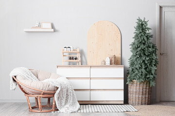 Interior of living room with armchair, commode and Christmas tree