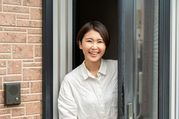 玄関先で笑顔の女性