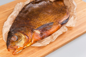 Cold smoked freshwater fish vyrezub on a wooden cutting board