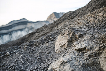 Close-up of rugged and textured mountain soil and rock surfaces, highlighting rough natural patterns, earthy tones, and weathered geological details with brown, gray, and orange variations.