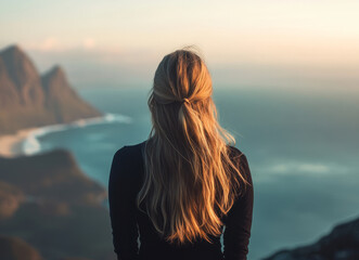 Fototapeta premium Portrait of a young woman at the top of a mountain