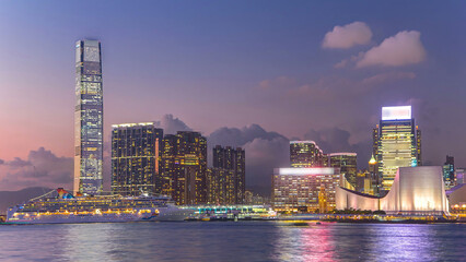 Hong Kong business center day to night timelapse with a cloudy blue sky before sunset