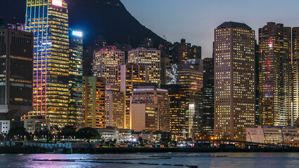 Hong Kong, China skyline panorama with skyscrapers day to night from across Victoria Harbor timelapse.