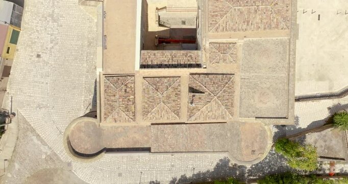 Perpendicular aerial view of a red tile roof. It is the castle of Bernalda, in the province of Matera, Basilicata, Italy. It has a rectangular shape and is located in the historic center of the town.