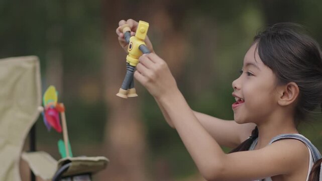 A girl is playing with a robot in the garden.