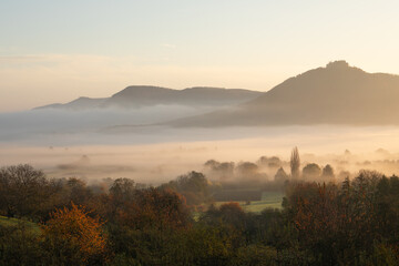 Blick auf die Burgfestung Hohenneuffen mit dem Albtrauf im Nebel zum Sonnenaufgang.  Schwäbischen Alb im Herbst. 