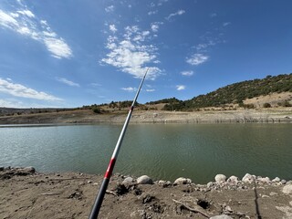 A fishing rod thrown into the water to fish on the shore of Ankara Çamlıdere Dam. Amateur fishing...