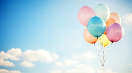 Colorful balloons floating against a clear blue sky.