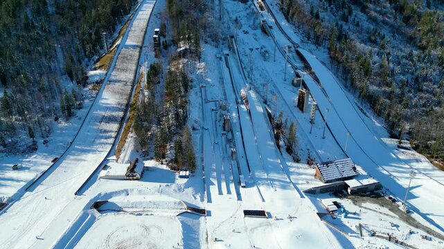 Planica Nordic Centre, nestled in the breathtaking Julian Alps of Slovenia, is a world-renowned destination for ski jumping and winter sports captured from a drone