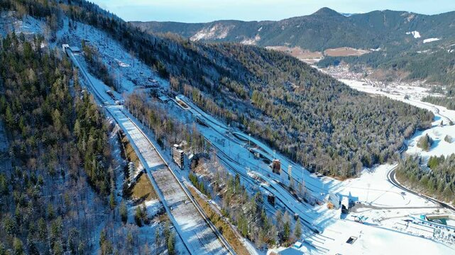 Planica Nordic Centre, nestled in the breathtaking Julian Alps of Slovenia, is a world-renowned destination for ski jumping and winter sports captured from a drone