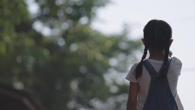 A girl is playing with a rocket in the garden.