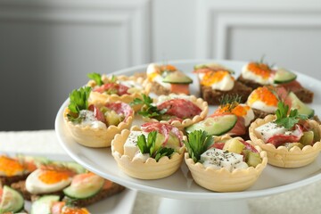 Many different tasty canapes on stand, closeup