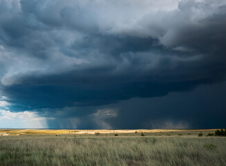 A stormy sky looming over a wide rolling plain.