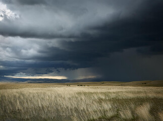 A stormy sky looming over a wide rolling plain.
