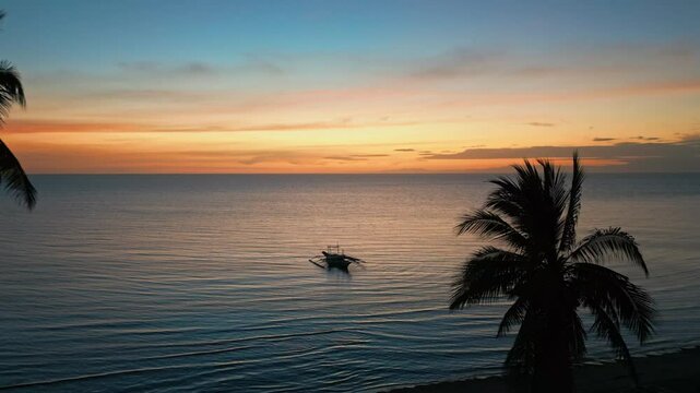 Sunset with a small Boat at the Beach with Palm Trees