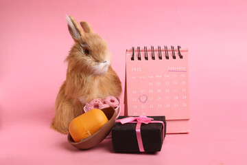 a figurine of a hare and a calendar with a mark for February 14