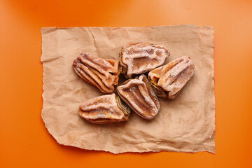 dried persimmon fruit on orange background