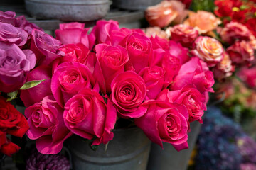 Bouquets of red, lilac, purple, and orange roses for sale.