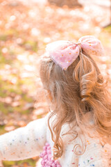 Naklejka premium little girl posing in an autumn environment with brown leaves