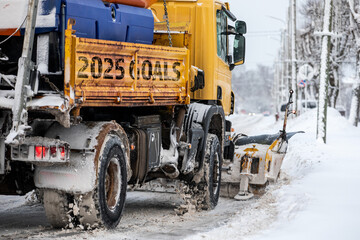 2025 Goals. A snowplow is shoveling snow on the street