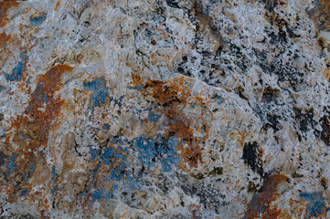 Background of natural rock that is pwhite, rust coloured and airforce blue texture