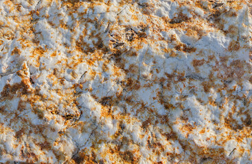 Background of natural rock that is rust coloured and white with a bumpy texture