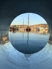 Durchblick auf einen ruhigen Hafen mit Spiegelung