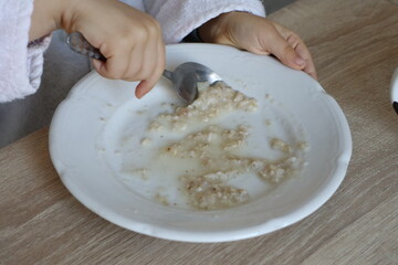 Savoring a Warm Bowl of Comforting Porridge with a Spoon at Breakfast Time with Cheer