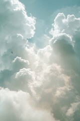 Fototapeta premium Bright sunlight filters through fluffy clouds in a clear blue sky