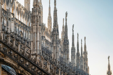 Naklejka premium Gothic architecture of Milan Cathedral with spires, statues, pinnacles and ornate decorations, Milan, Lombardia, Italy. Close up of Duomo di Milano with intricate detailed architecture