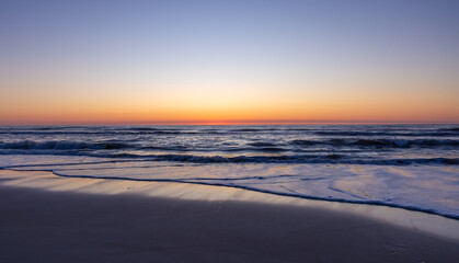 Gentle waves lap up on the shore of the Outer Banks at dawn