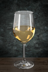 Glass with white wine on wooden table on grunge style wall background. Bar theme. Dark environment. 3d rendering.
