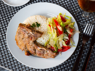 Pork chop with rice and vegetables. Latin American cuisine