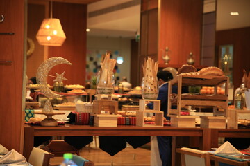 Beautifully arranged buffet featuring an array of dishes and decorative elements, showcasing a blend of culinary artistry and cultural influences, set in a warm, inviting atmosphere