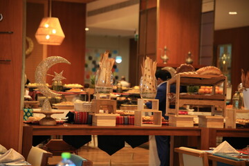 A beautifully arranged buffet featuring an array of dishes and decorative elements, showcasing a blend of culinary artistry and cultural influences, set in a warm, inviting atmosphere