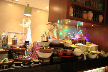 A vibrant buffet setup showcasing a variety of colorful dishes, elegantly arranged with festive decor and twinkling lights, creating a warm and inviting atmosphere for dining
