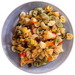 Salad of pasta, vegetables, and seafood has been prepared. Composition includes crab sticks, pasta, raisins, corn. Non-traditional recipe, varied cuisine, home cooking. Isolated over white background