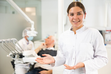 Young female nurse during examination of patient in dental office