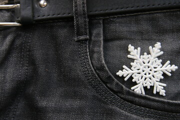 Winter concept, snowflake in jeans pocket