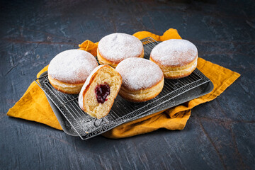 Authentic traditional German festive Berliner Krapfen - jam doughnut with icing sugar as close-up...