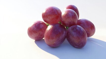 Obraz premium A cluster of shiny red grapes resting on a light surface, showcasing their natural beauty.