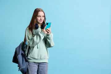 Perplexed person having shocked look on face while reading messages on mobile phone, feeling shocked after receiving bad news. Young girl feeling puzzled by weird SMS on cellphone, studio backdrop
