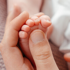 A newborn baby's feet in mom s hands close-up. High quality photo