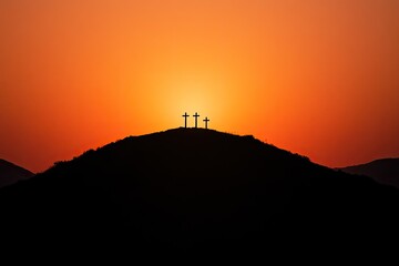 A silhouette of a hill with three crosses at sunset