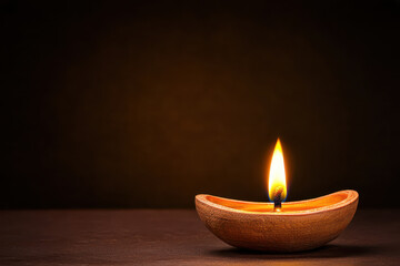 glowing diya candle radiates warmth and light in dark setting, symbolizing hope and celebration