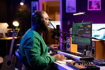 African american musician performing an acoustic version of his track, recording new song on...