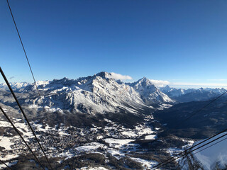 Winter view from the ski lifts in Cortina d&rsquo;Ampezzo, showcasing snow-covered mountains and the charming town below
