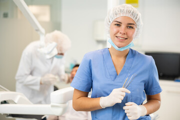 In dentists office, girl nurse before start of appointment and working day. Positive medical...